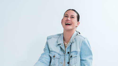 Person wearing a light blue denim jacket against a white background