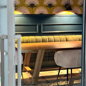 Modern interior with a wooden table and bench against a decorative wall.