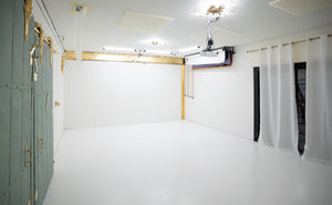 Photography studio with white and gold walls, equipped with lighting and a projector