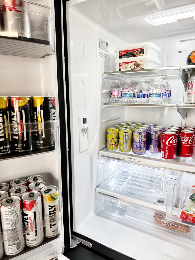 Open refrigerator with various drinks including Coca-Cola and Truly.