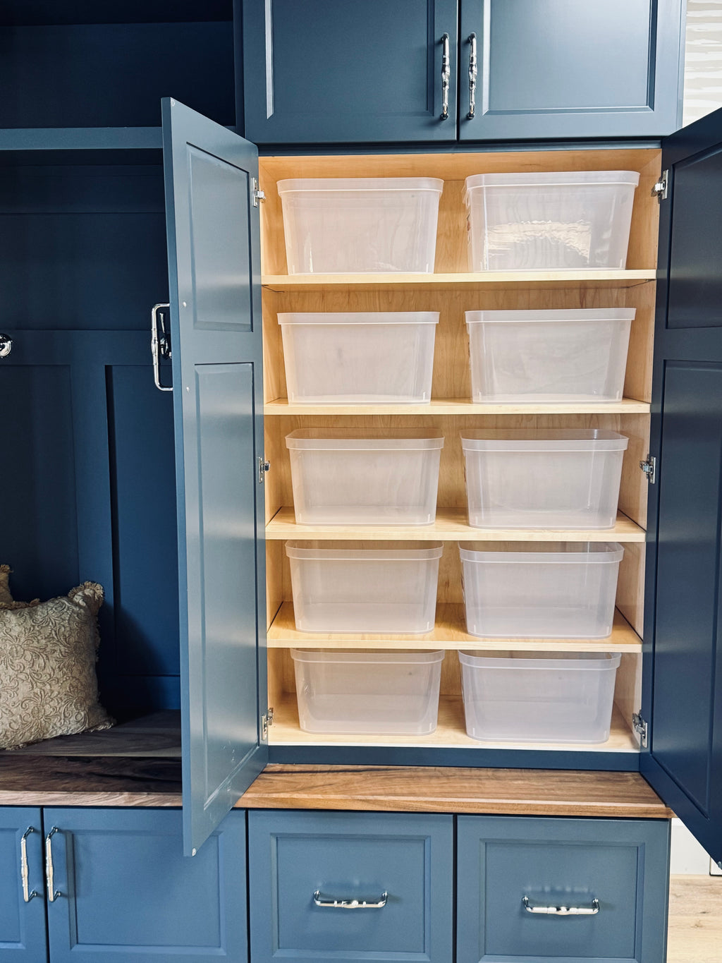 Blue storage cabinet with open doors revealing wooden shelves with clear plastic bins.