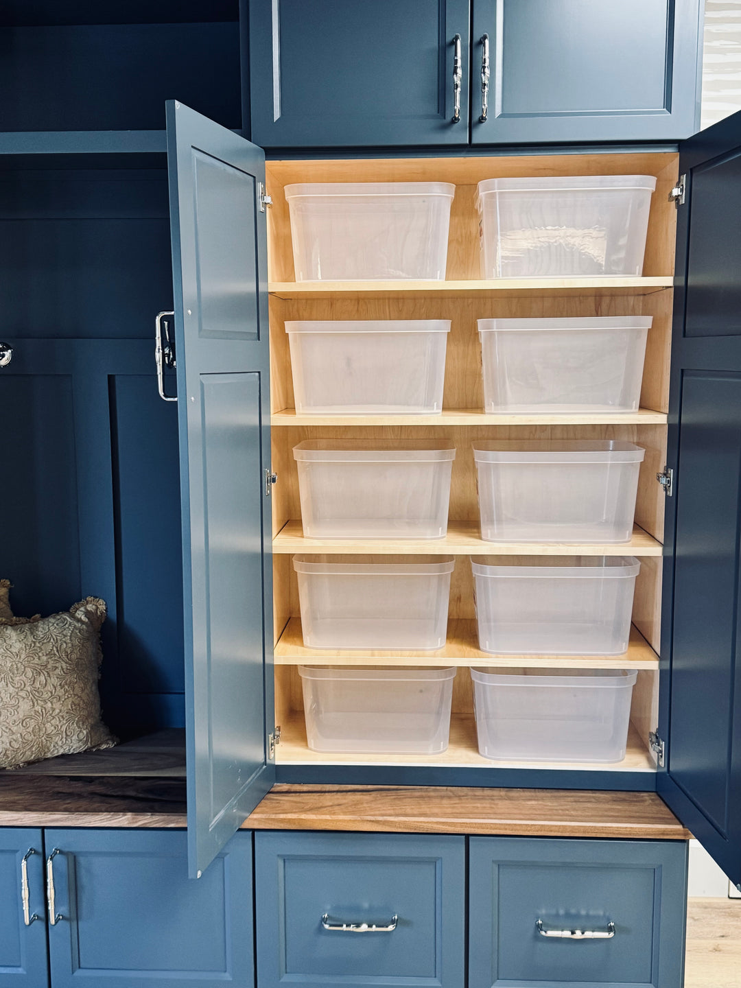 Blue storage cabinet with open doors revealing wooden shelves with clear plastic bins.